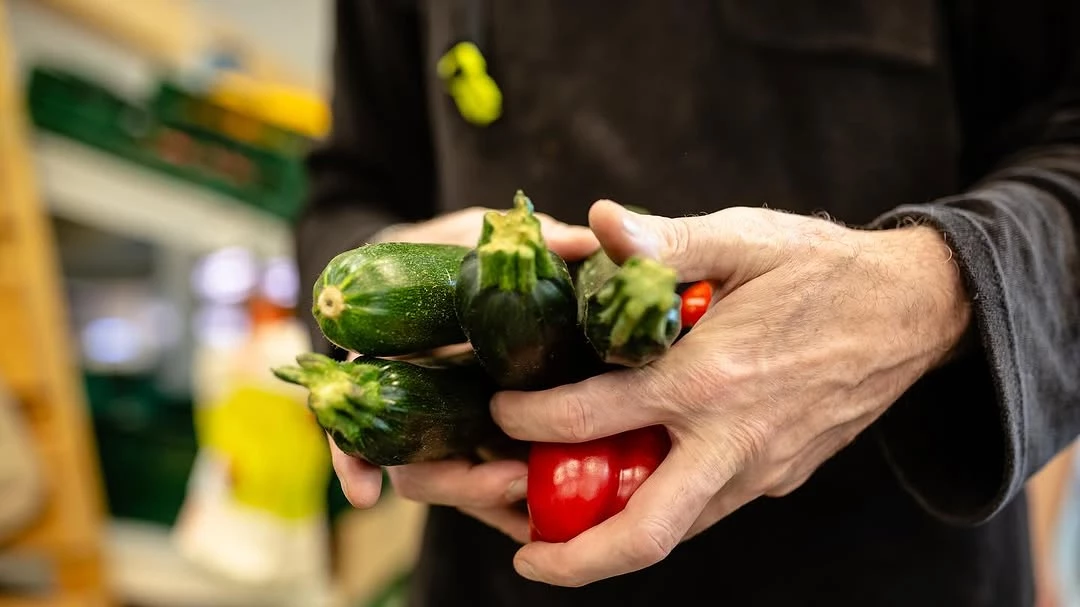 Eines unserer Mitglieder mit Zucchinis und Tomaten