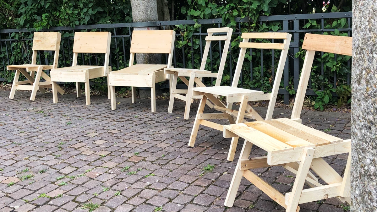 Sechs verschiedene selbst gebaute Stühle auf einem Platz