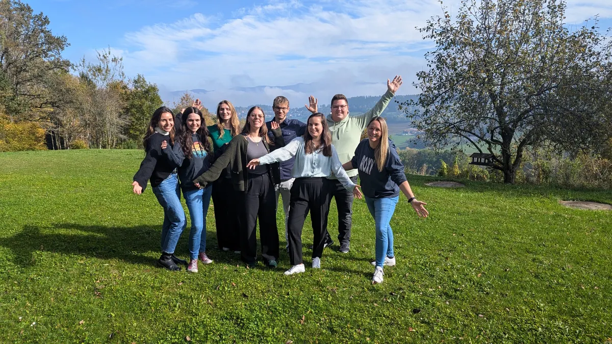 8 Personen stehen auf einer Wiese.