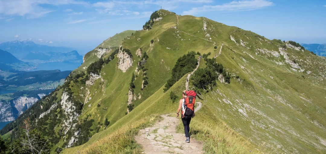 Person mit rotem Rucksack wandert durch die Berge 