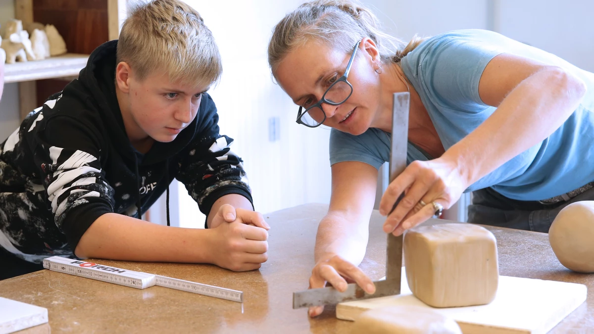 Lehrerin und Schüler in einem künstlerischen Unterricht