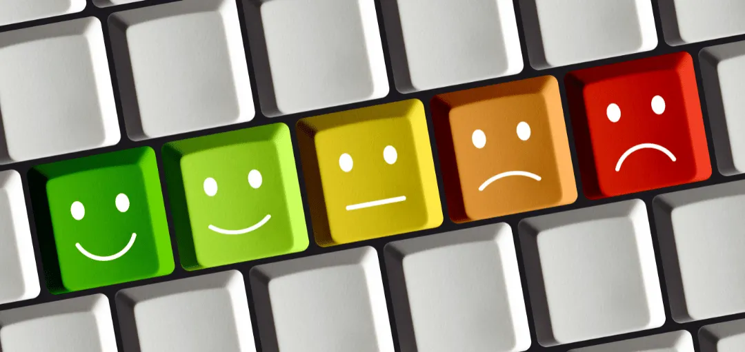 Tastatur mit farbigen Tasten, die von grünem Lächeln bis rotem traurigen Gesicht reichen – symbolische Bewertungsskala zur Einschätzung eines Zwischenzeugnisses.