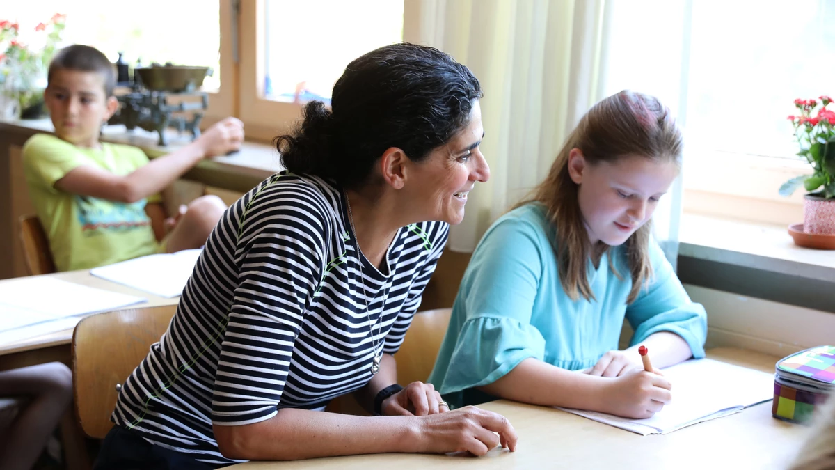 Schülerin und Lehrerin am Schreibtisch