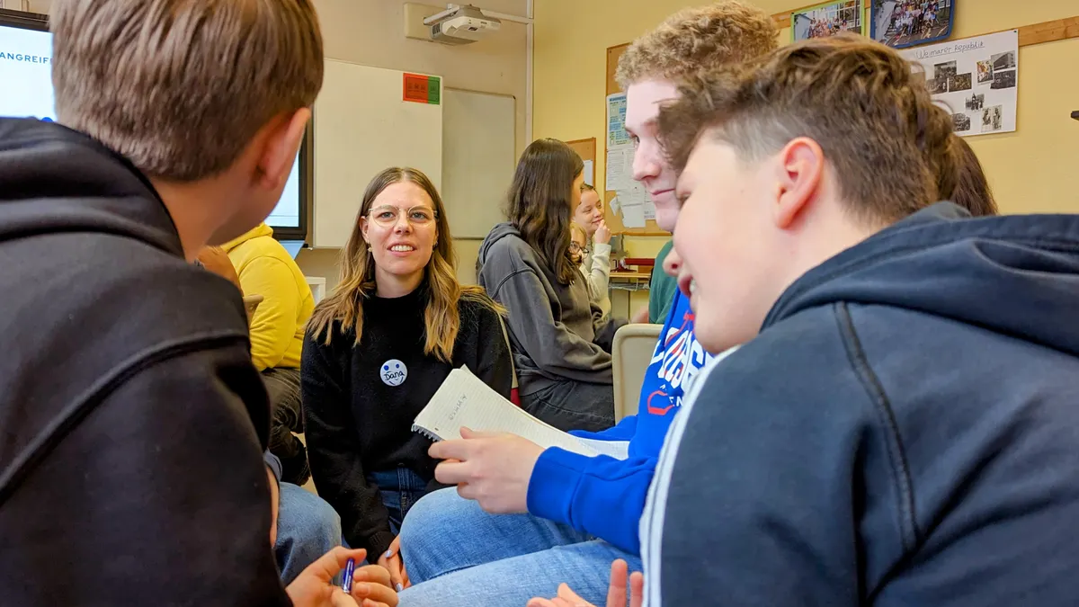Ein Social Visionary ist im Klassenraum im Austausch mit Schüler:innen.