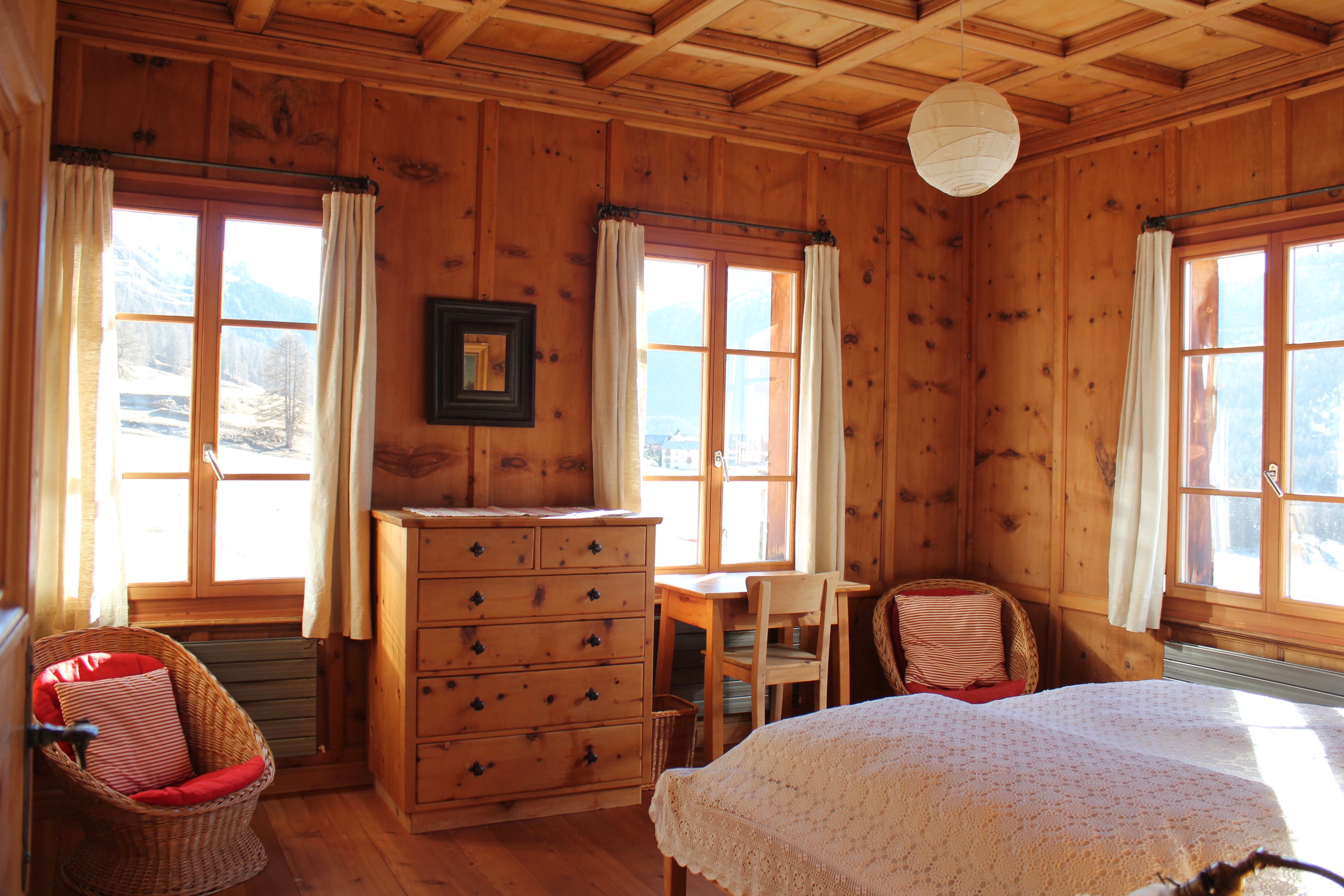 Schlafzimmer mit Holzvertäfelung und rustikaler Einrichtung. 