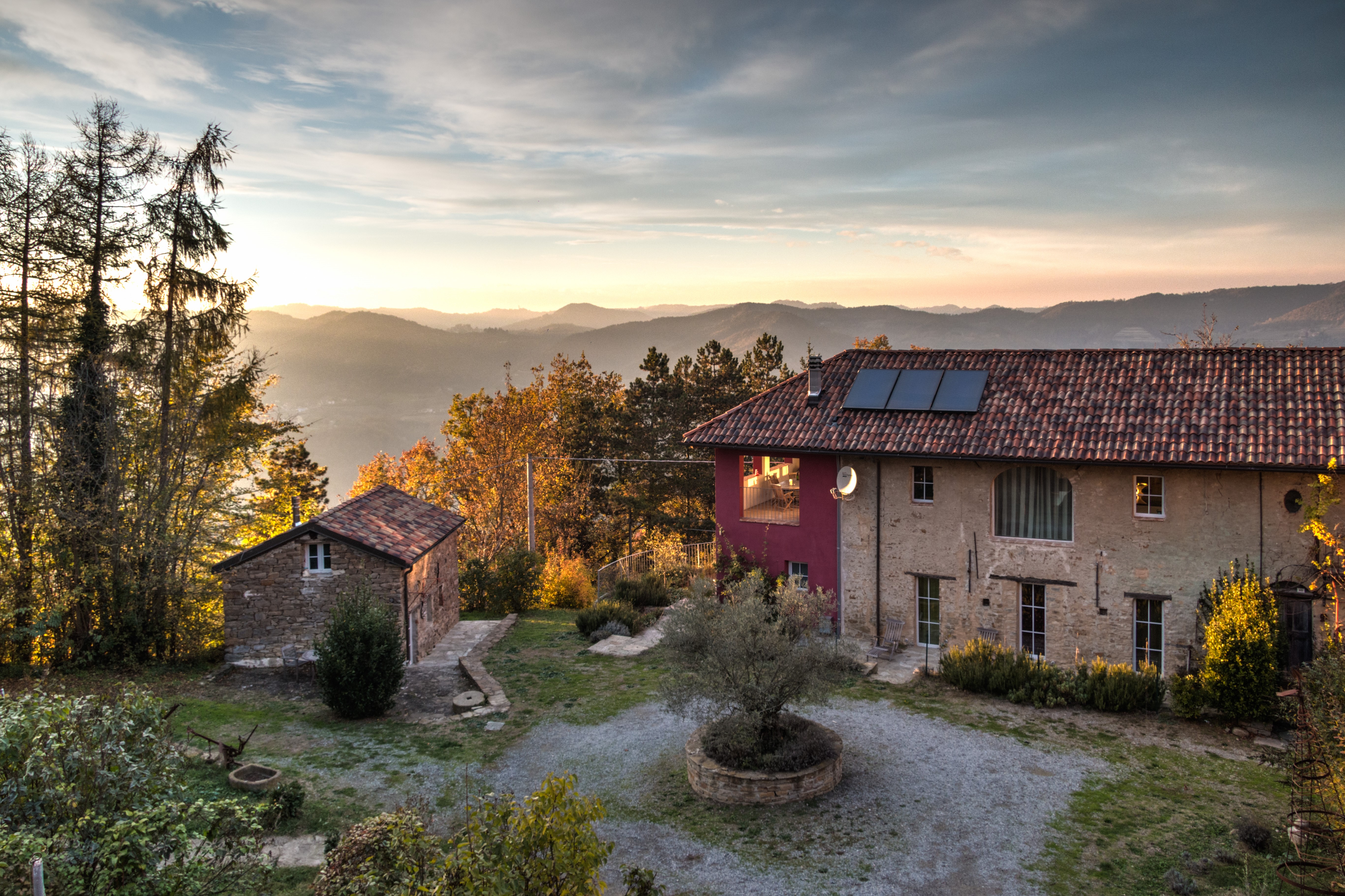 Italienisches Landhaus mit grünem Innenhof vor Bergpanorama