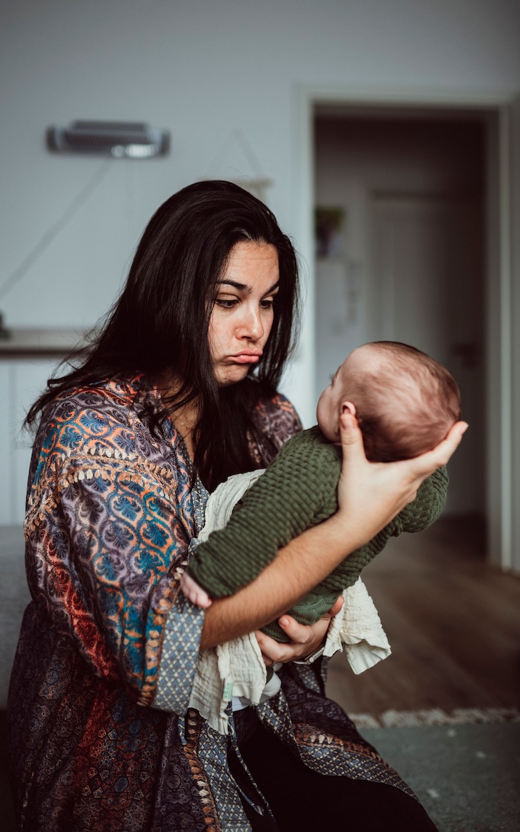 Eine Mutter macht ein lustiges Gesicht zu ihrem Baby, das sie auf dem Arm hält